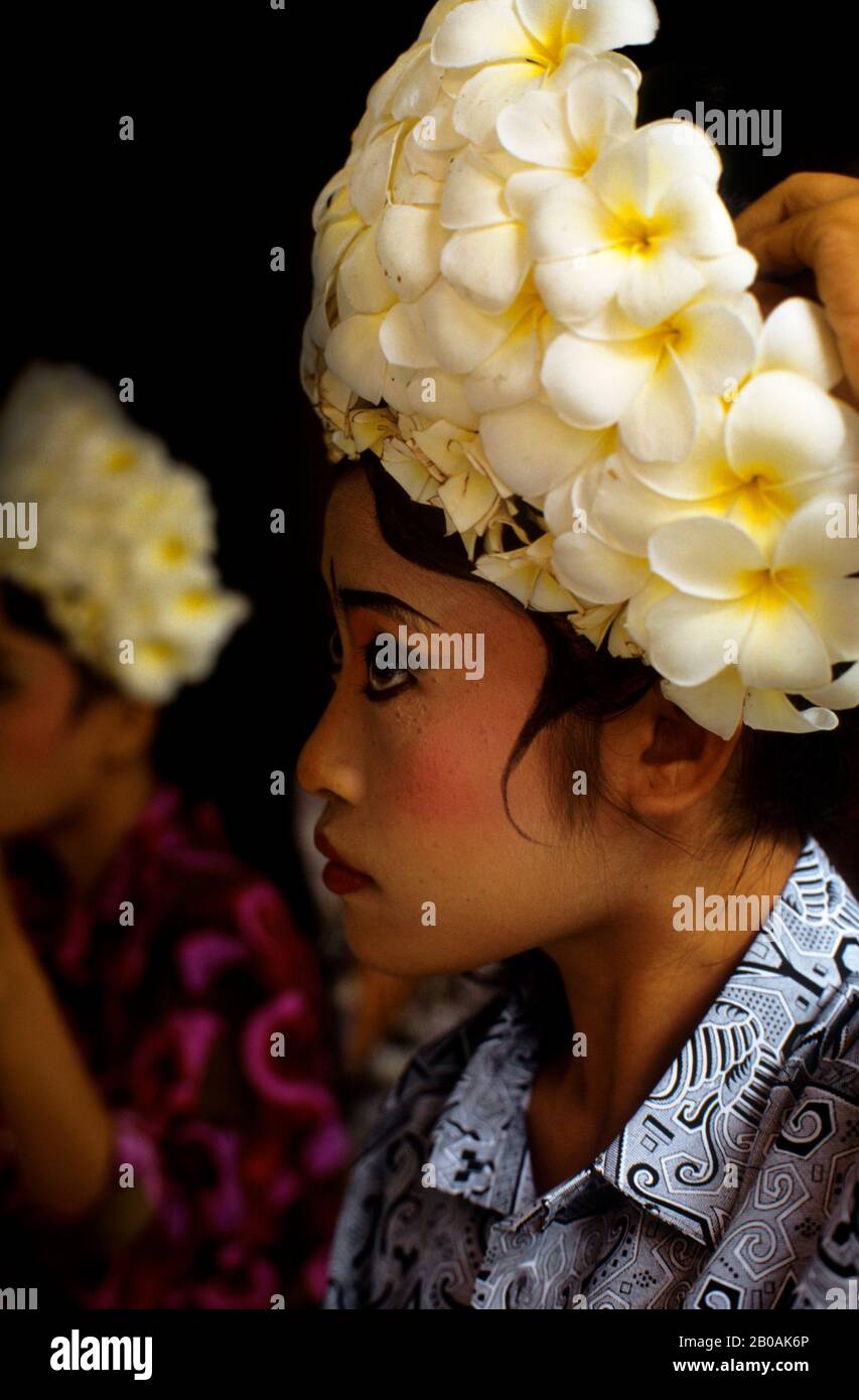 INDONESIA, BALI, BARONG DANCE, DANCER PREPARING COSTUME, FRANGIPANI FLOWERS Stock Photo