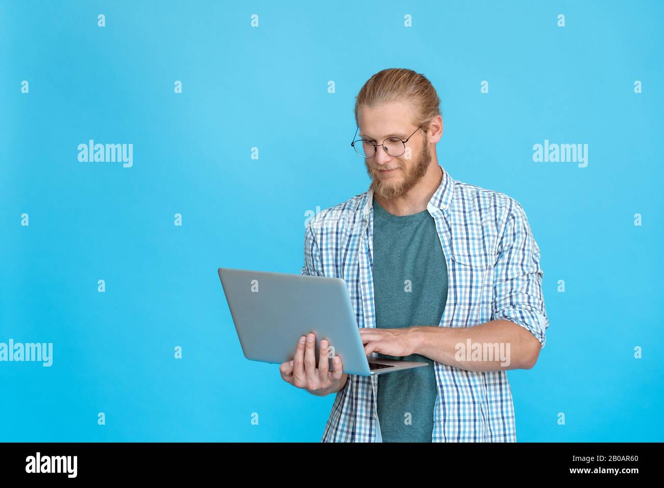 Bearded young businessman student hold modern laptop type e-mail copy space Stock Photo