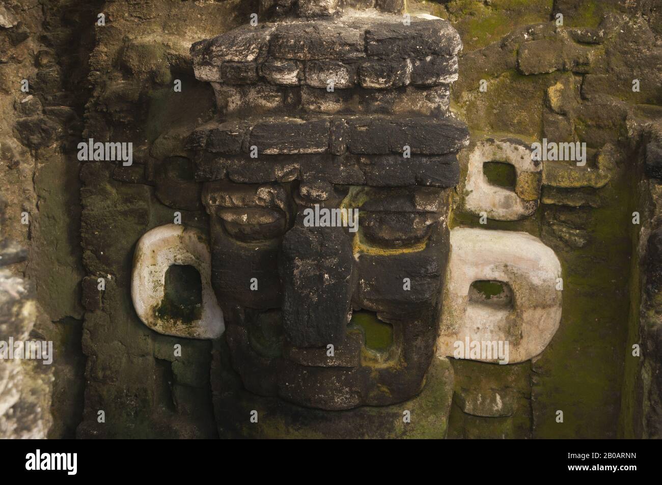 Guatemala, Tikal National Park, Gran Plaza, Templo II, Temple of the Masks, 8th c AD, stone mask; UNESCO World Heritage Site Stock Photo