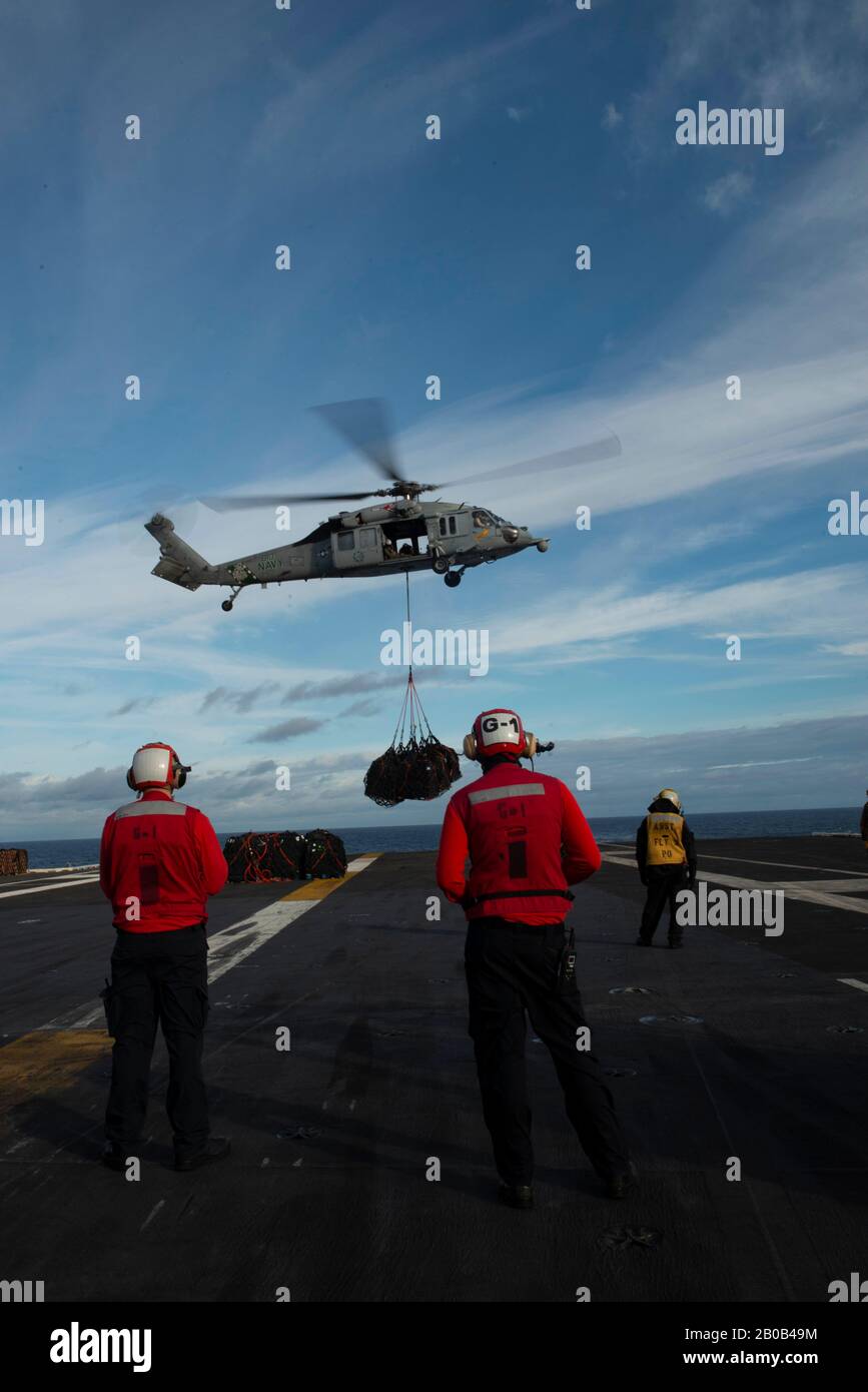 200218-N-DM241-1028  ATLANTIC OCEAN (Feb. 18, 2020) Sailors observe an MH-60S Sea Hawk, assigned to the 'Dusty Dogs' of Helicopter Sea Combat Squadron (HSC) 7, deliver cargo during a vertical replenishment aboard the aircraft carrier USS Dwight D. Eisenhower (CVN 69). Ike is conducting operations in the Atlantic Ocean as part of the USS Dwight D. Eisenhower Carrier Strike Group. (U.S. Navy photo by Mass Communication Specialist 2nd Class Elizabeth Cohen/Released) Stock Photo