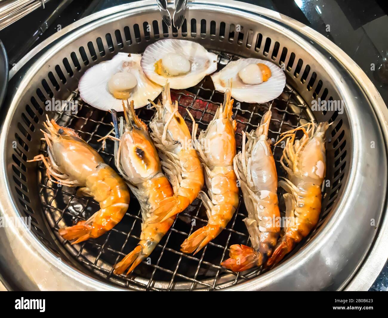 Grilled big shrimp and scallop on the kiln. Seafood barbecue for family