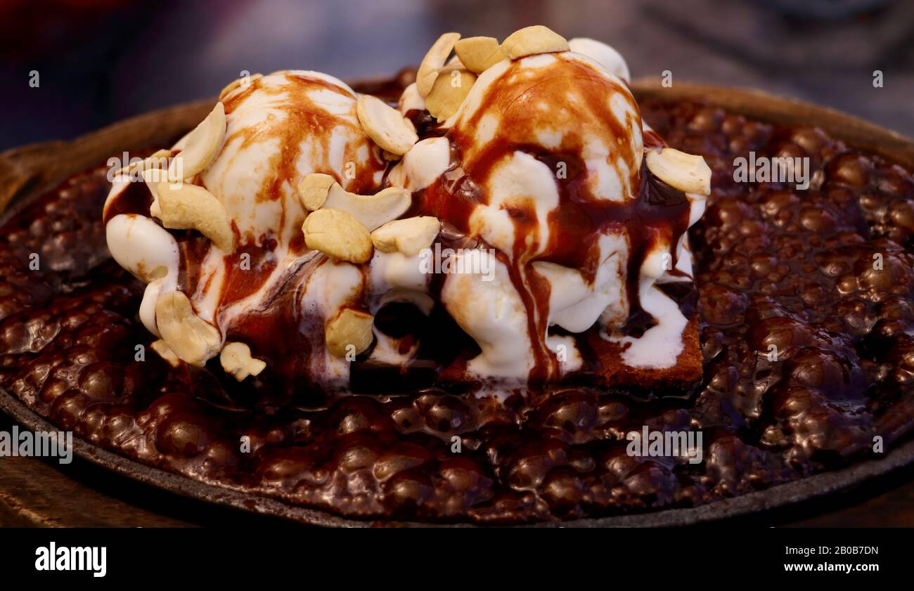 Hot sizzling chocolate brownie with nuts and ice cream Stock Photo