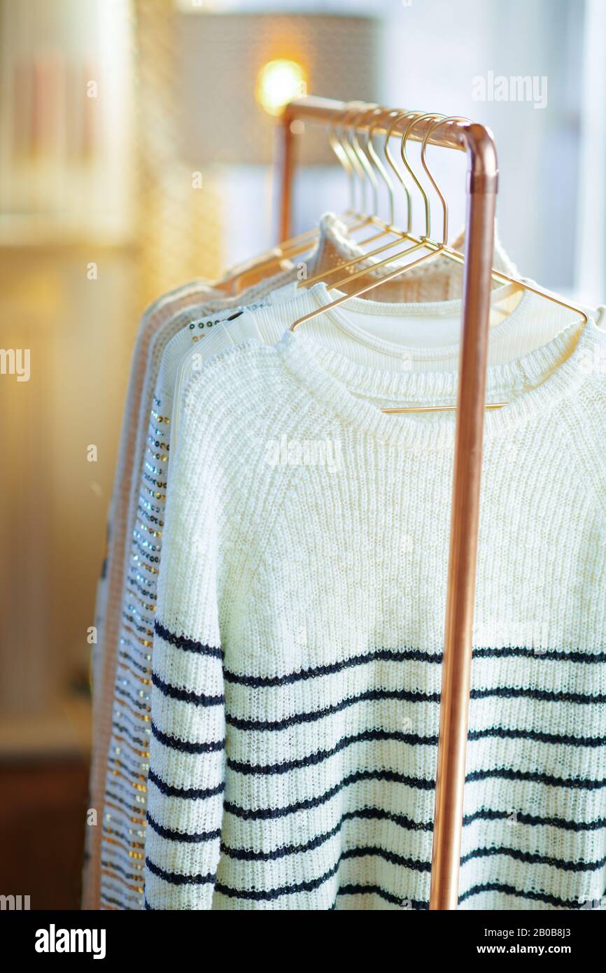Closeup on modern copper clothes rack with clothes on hangers Stock