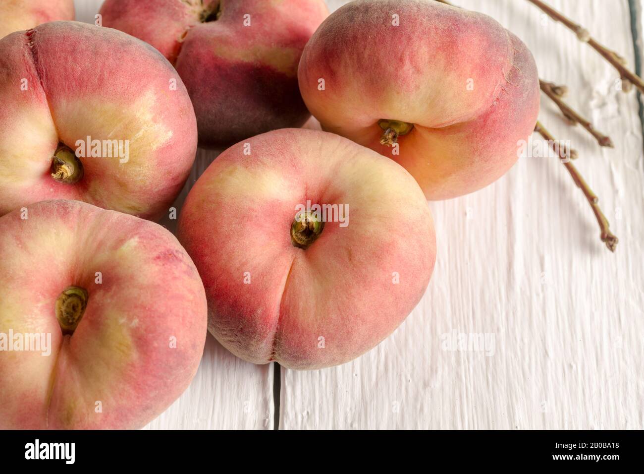 Donut peaches on white rustic table - horizontal closeup image with selective focus Stock Photo
