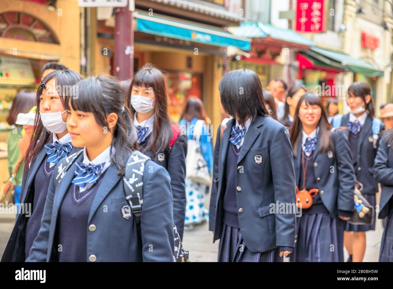 Yokohama, Japan - April 21, 2017: group of asian girls in school uniform wear a mask while walking in the heart of Yokohama Chinatown, the Japan's Stock Photo