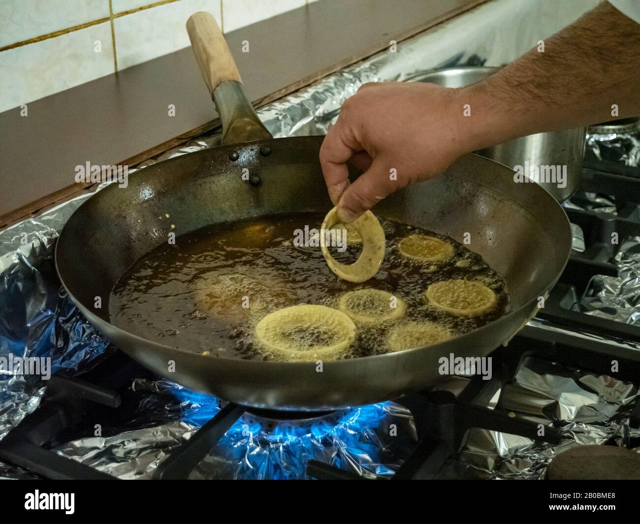 https://c8.alamy.com/comp/2B0BME8/a-chef-deep-fries-indian-pakora-onion-rings-in-hot-oil-over-a-gas-stove-in-a-restaurant-kitchen-2B0BME8.jpg