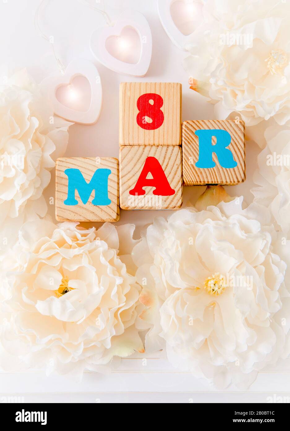 International Women's Day calendar greeting card background. With wooden hearts, pastel color flower blossoms and text 8 mar. Stock Photo