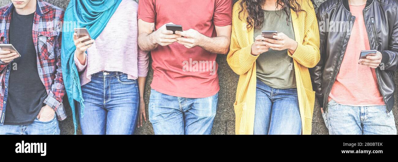 Group of millennial friends watching social stories on smart mobile phones - People addiction to new technology trends - Concept of youth, texting, so Stock Photo