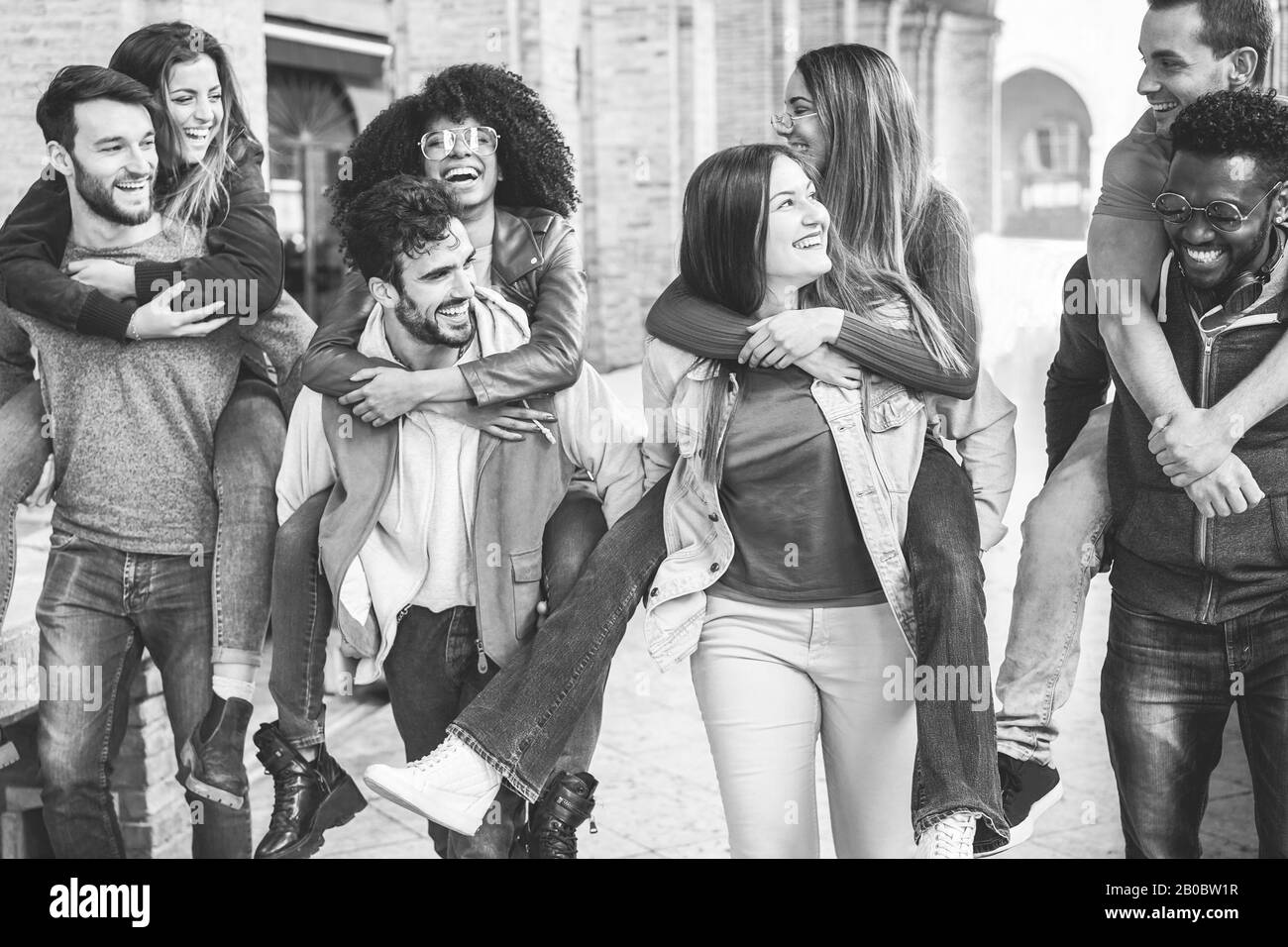 Young millennial friends having fun in old city center - Happy students at university laughing together - Youth, school and friendship concept - Focus Stock Photo