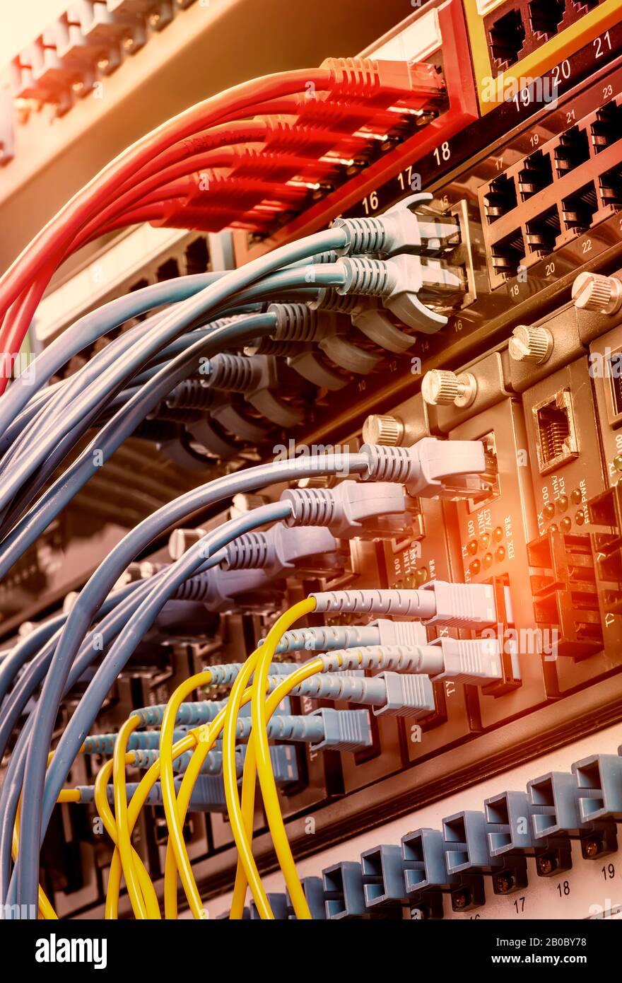 Fiber Optic cables connected to optic ports and UTP, Network cables connected to ethernet ports. Stock Photo