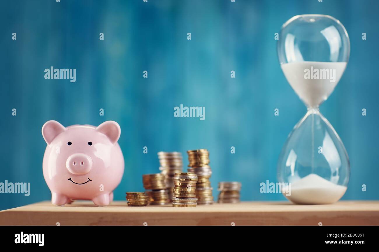 piggy bank with stacked coins and hourglass Stock Photo