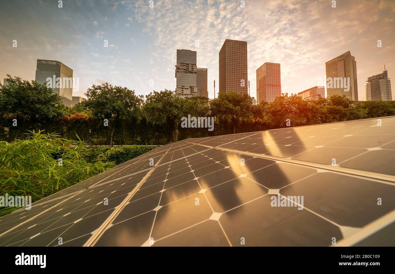 Ecological energy renewable solar panel plant with urban landscape landmarks Stock Photo