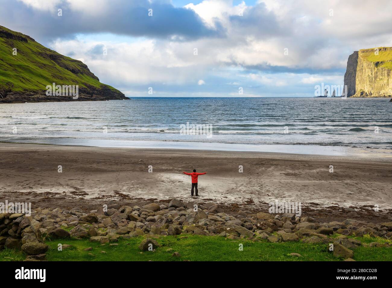 Tourist standing at the beach in Tjornuvik in the Faroe Islands, Denmark Stock Photo