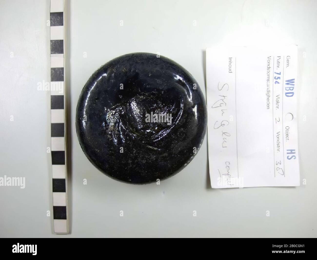 iron complete, diameter 8.4-8.6 cm, dark black-green glass, impurities of small whiter pieces (max. 1 mm diameter), height 4.1 cm, iron, glass, diameter 8.4 -8.6 cm, height 4.1 cm, vmec, Netherlands, Utrecht, Wijk bij Duurstede, Wijk bij Duurstede, Dorestad Stock Photo