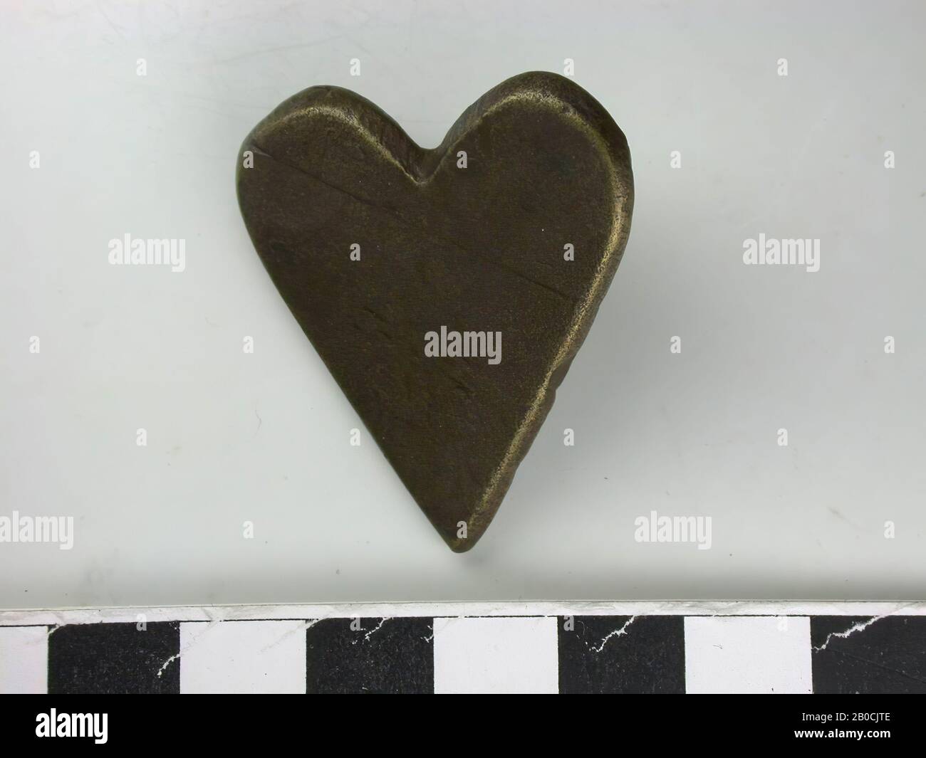 Heart shape, gold (copper alloy). Heart shape, with flat back and one attachment pin (L: 0.9cm) and traces of a second., Belt stroke, metal, copper alloy, L: 4,0 cm, W: 3,4 cm, H: 1,3 cm, end 14th century 1350-1400, the Netherlands, Zeeland, Hulst, Verdronken Land Stock Photo