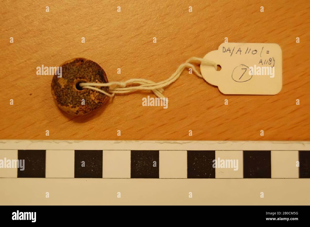 Round, flat bead, grave inventory, ornament, glass (?), Brown brittle material, D 2 cm, H 0.9 cm, D hole 0.3 cm, Islamic Period 1250-1600 AD, Jordan Stock Photo