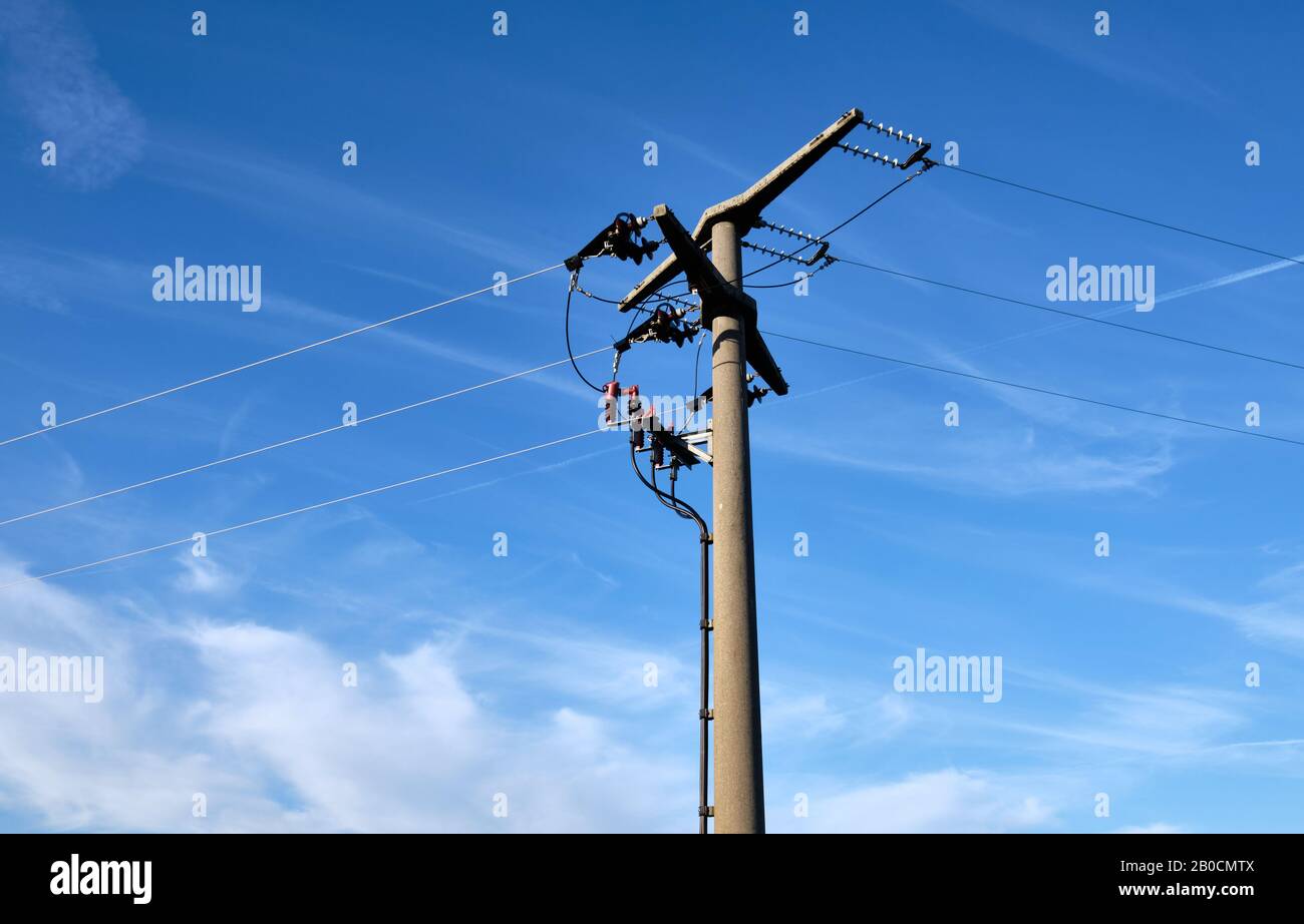 Close-up of a high voltage pylon made of concrete seen from below against blue sky with copy space in Germany Stock Photo