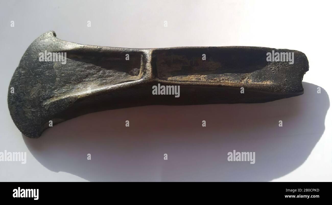 This is a bronze stopridge ax of the Vlagtwedde type. The specimen has a dark to black patina, possibly due to the many decades in which it has been handled by the owners. As a result, a golden patina appears, typical of a river context. The piece is further rounded. The sides show the remains of a casting seam. The back has a damage (chip). The front has been damaged in the past. The edge then seems to be cut into a single whole again. On both sides of the front are scratches (grinding marks Stock Photo