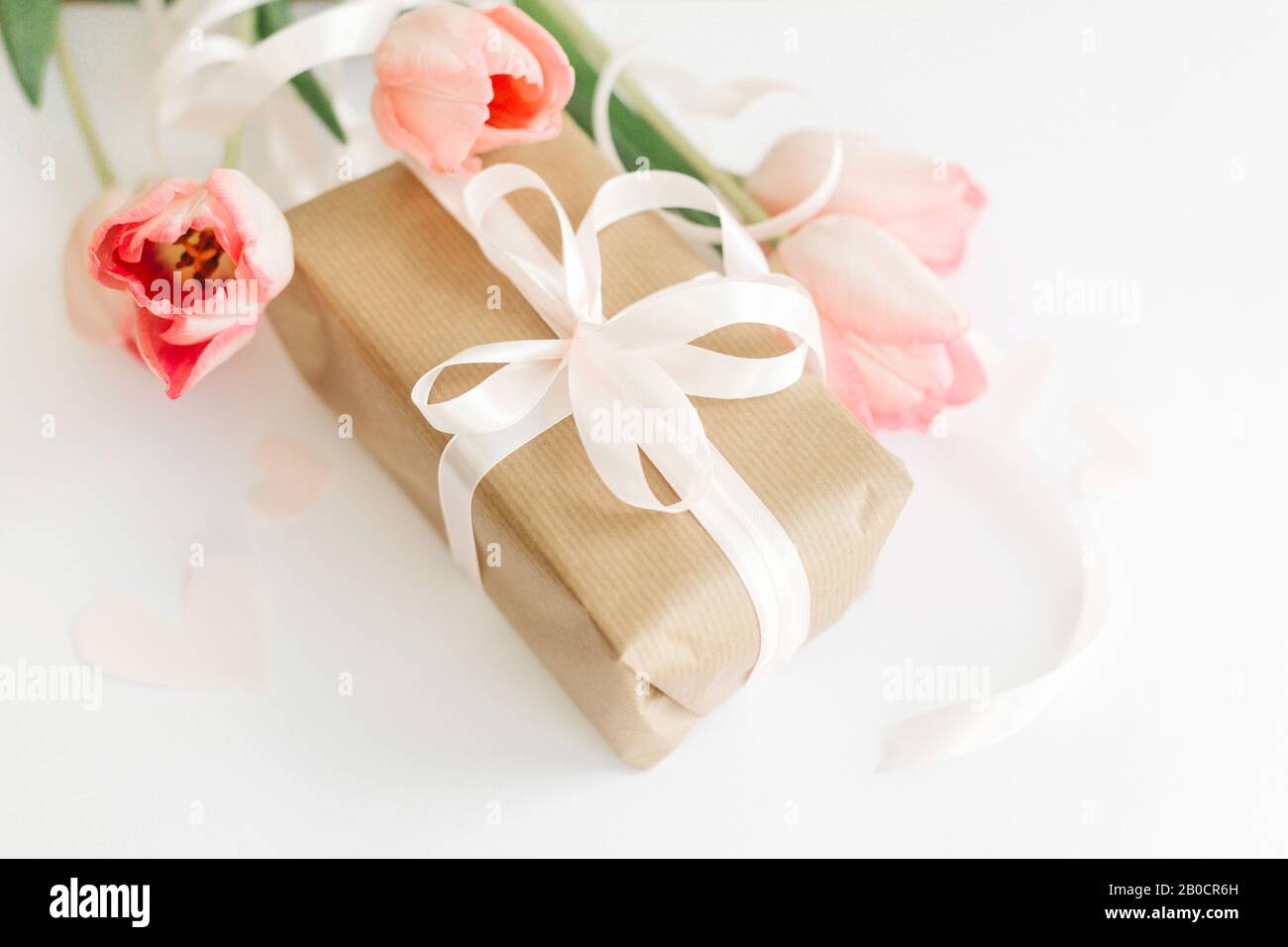 Pink tulips with ribbon and gift box on white background. Stylish soft ...