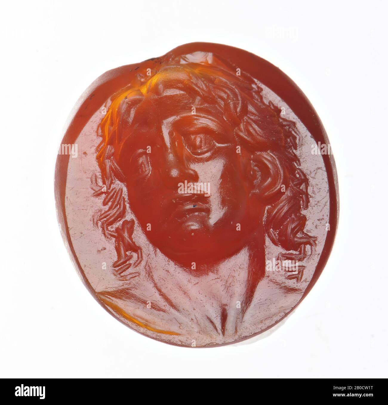 Vz: the thick face with open lips and big eyes is depicted with long, curled hair., Gem, intaglio, ringstone, carnelian, Color: bright red, Shape: round, Processing:, Method: modeling with rounded drills , detailing with short rounded wheel grooves, 12 x 11 mm, D. 13 mm, 2nd century BC. -200 Stock Photo
