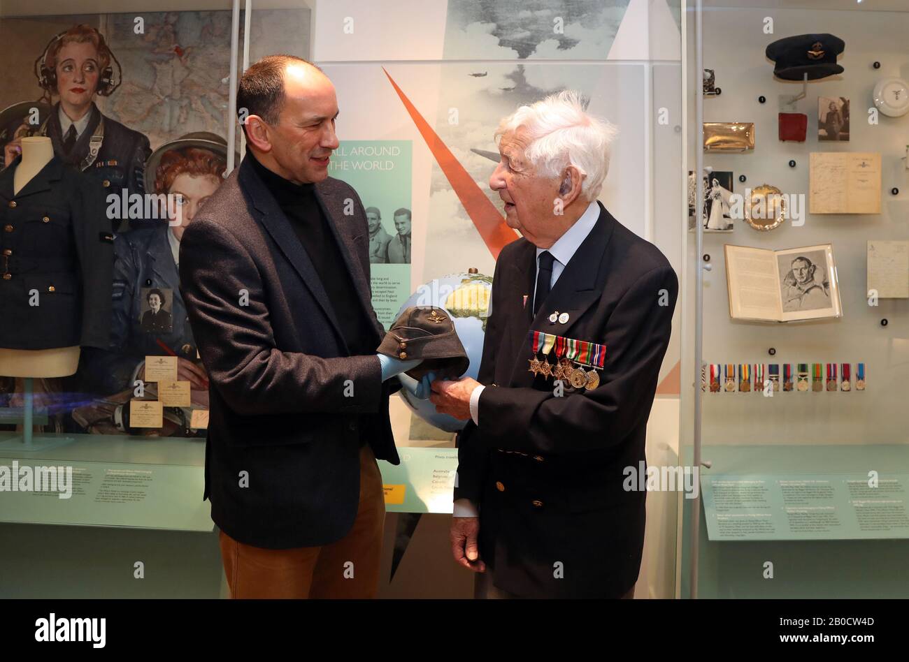 World War Two veteran Peter Lemon, a Wireless Operator Air Gunner and bomber crew, is shown the cap of Battle of Britain pilot Flight Lieutenant Alan Deere by Trustee Angus Patterson during the press launch for the Battle of Britain 80th anniversary commemorations at the Biggin Hill Memorial Museum in Kent. Stock Photo