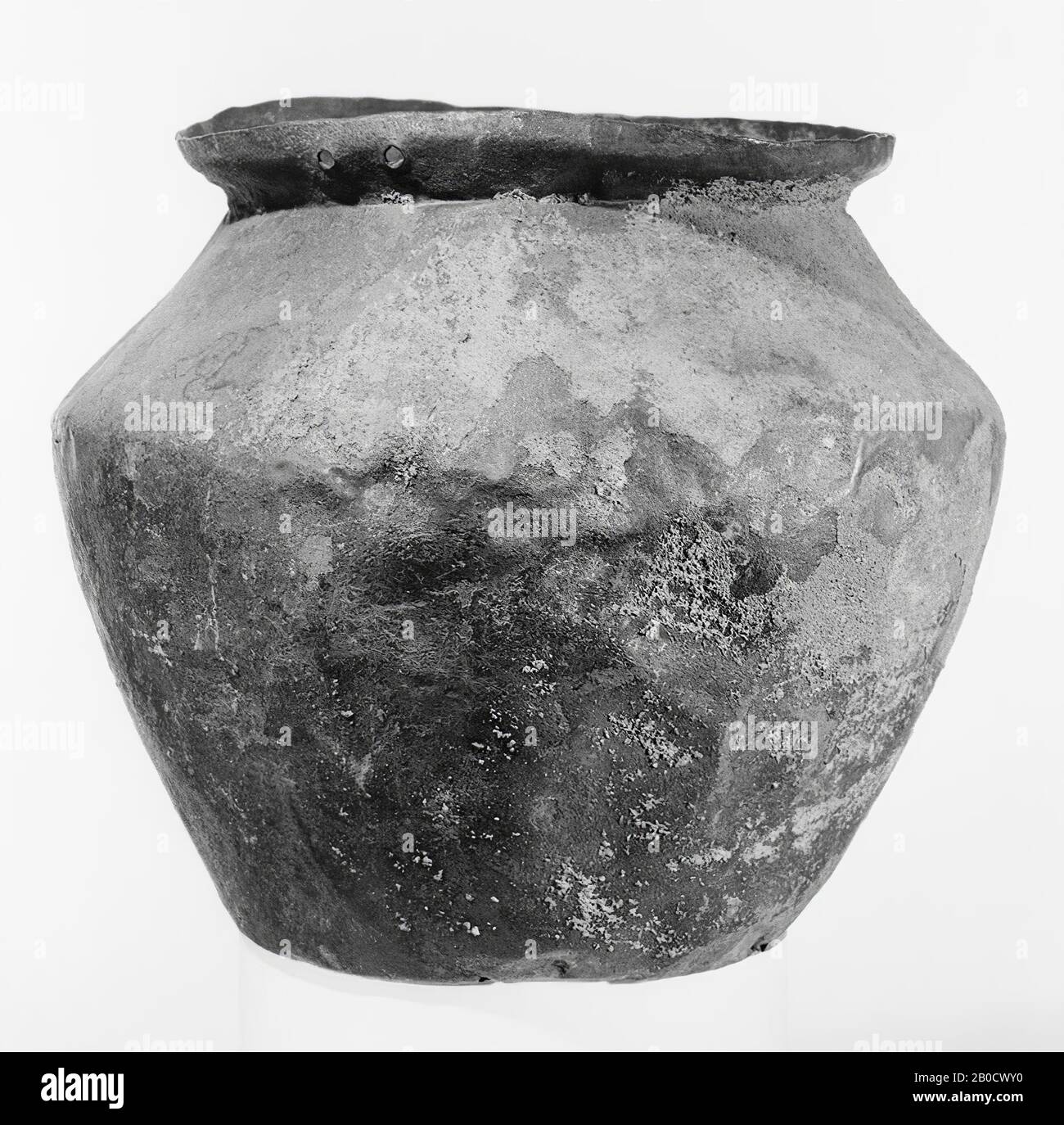 Small bronze bucket with slightly dented soil. Wide, bulging belly, the largest width of which lies above the middle. Narrow, slanting outward edge, the upper part of which is more vertical. Attaches and handle are missing, but the rivet holes for confirmation are still present, 2 pairs, facing each other. Bruijne patina, at the top partly river sand occupation, crockery, bucket, metal, bronze, height: 17.1 cm, Roman 1-300, Netherlands, Gelderland, Nijmegen, Nijmegen Stock Photo