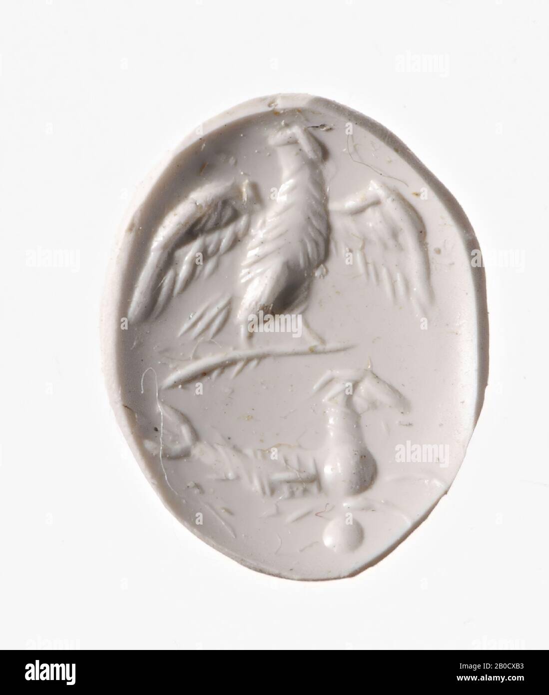Vz: eagle on a scepter and a capricorn on a globe., Gem, intaglio, ring stone, agate, Color: with brown top layer, Shape: oval, Machining: front convex, Method: modeling with rounded drill, detailing with thin rounded wheel grooves., 12 x 9.5 mm, D. 3.5 mm, 1st century AD. 1-100 AD Stock Photo