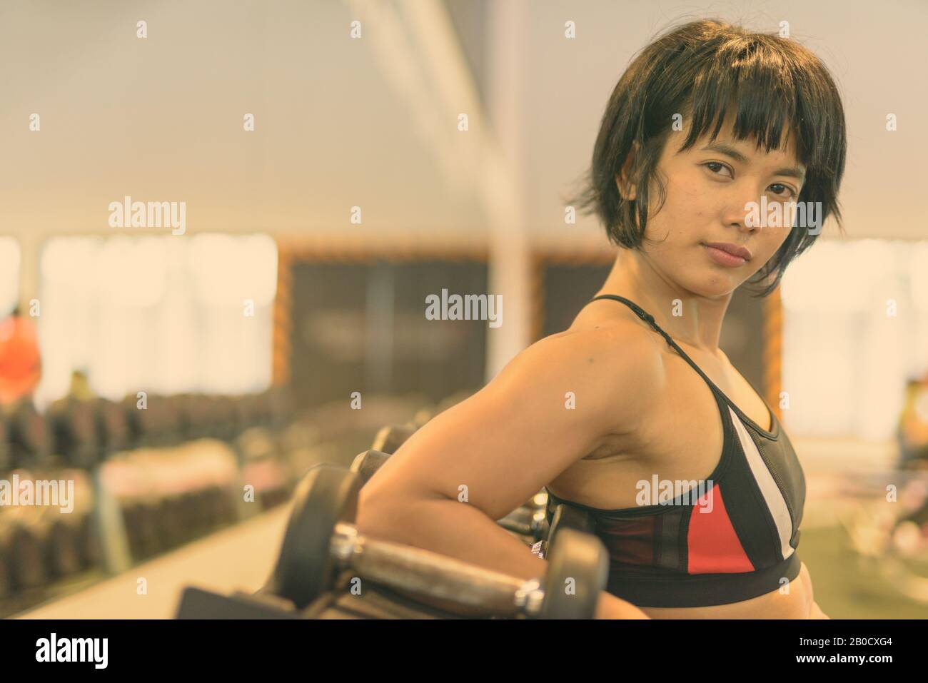 Young beautiful Asian woman working out at the gym in black and white Stock Photo