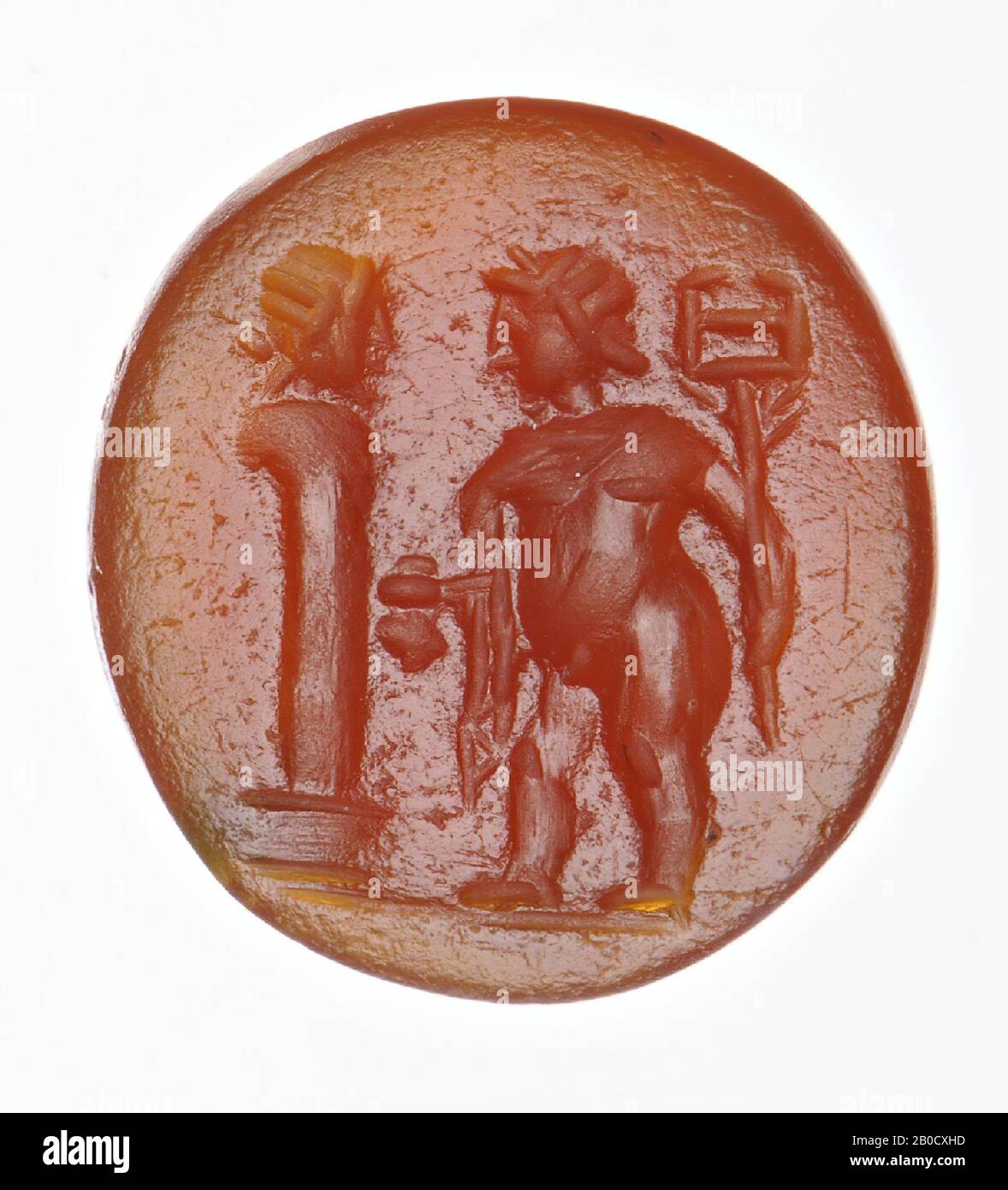 Vz: a fat boy, probably Cupid although there are no wings visible, has a caduceus in his left hand and a money bag in his right hand, he carries a chlamys over his shoulders, he looks at a herm placed on a pedestal for him., gem, intaglio, ringstone, carnelian, Color: yellowish brown, Shape: oval, Machined: edge cut at the front compared to the rear, Method: body modeling with large rounded drills, detailing with short rounded wheel grooves. , 10 x 8 mm, D. 3 mm, end of the 1st century AD. 75-100 AD, Turkey Stock Photo