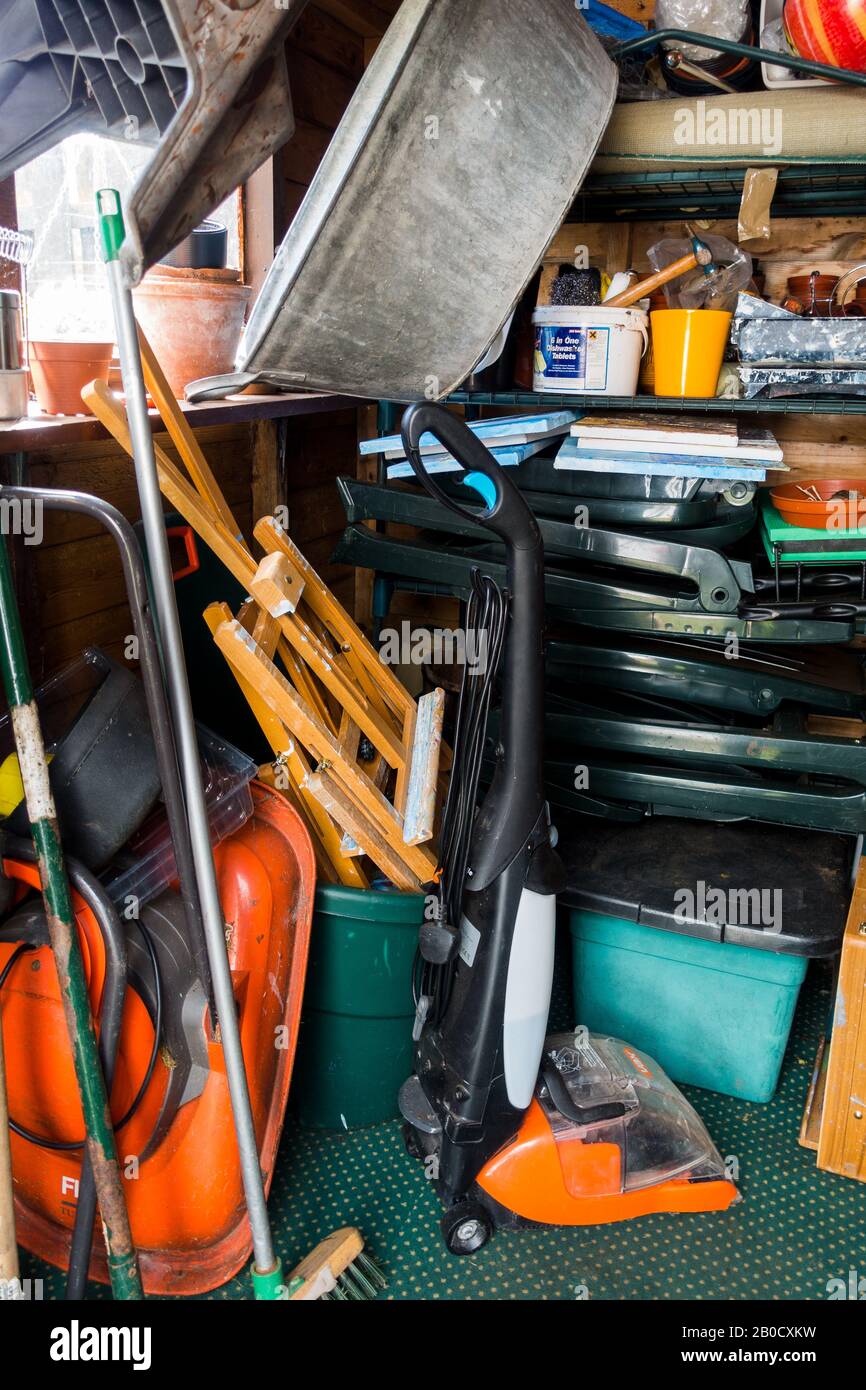 garden shed with door open showing disorganised contents. Scotland UK Stock Photo