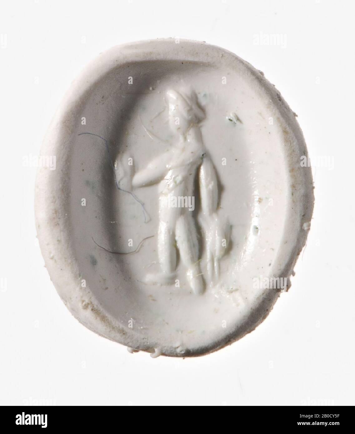 Vz: Bonus Eventus with one arm raised and the other along his body., Gem, intaglio, ringstone, heliotrope, Color: greenish black, Shape: oval, Processing: edge at front cut backwards compared to at the back , Method: body modeling with thick rounded disk grooves., 11 x 8 mm, D. 3 mm, 2nd - 3rd century AD. 100-300 AD Stock Photo