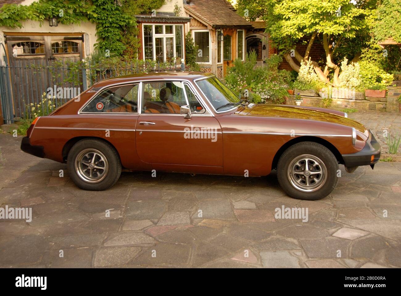 Russet brown MGB Gt sports car on drive of suburban house Stock Photo