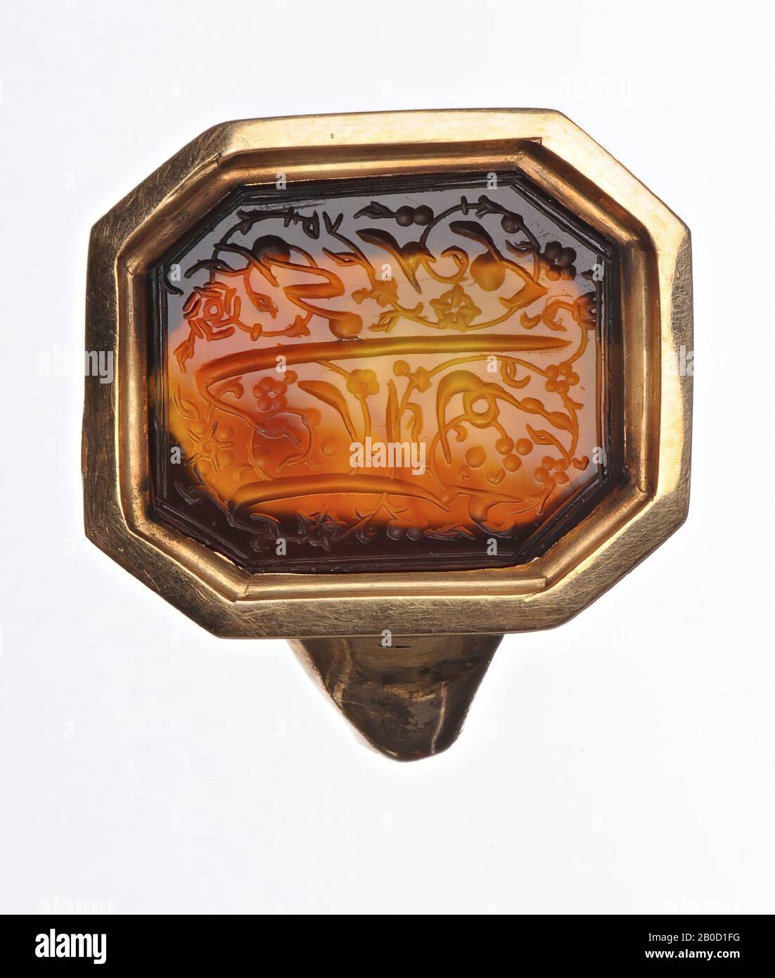 Vz: Arabic text in 2 lines in the shape of arabesque: Khuweed Mohamed, gem, intaglio, carnelian, Color: brown-yellow mottled, Shape: octagonal, Processing: in broken off copper ring, Type :, 14 x 16 mm, D. 2 mm, wt. 4.18 gr., 9th - 13th century AD? 800-1300 Stock Photo