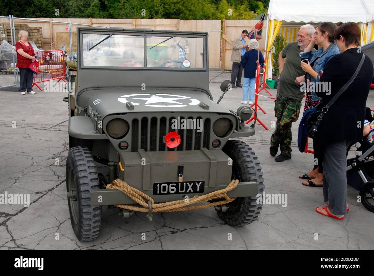 People admiring a green US army military Jeep at small local motor show Stock Photo
