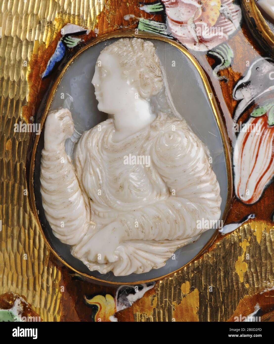 Vz: the woman wears a richly pleated robe and a cloak with fibula on the left shoulder, with her left hand she holds up her robe, the right hand has raised it to her mouth, she has a complicated hairdress., Cameo, chalcedony (?), Color: greyish blue Stock Photo