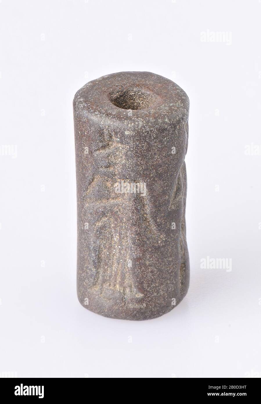 Vz: god with club and follower, goddess, empty place for inscription, roll seal, iron-containing flint, Color: dark brown, Shape: cylinder, Processing:, Method: L. 17 mm, Diam. 8.5 mm, 1st Dynasty Babylon Stock Photo