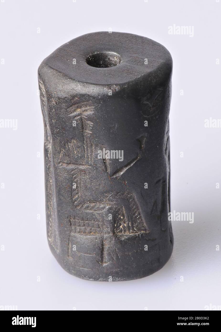 Vz: seated god, rooster and crescent moon, follower and goddess, vase and bread, standing god with saw (?) And follower, three balls and triangle, coil seal, quartz matite, Color: black, Shape: cylinder, Machining :, Method of manufacture: L. 24 mm, Diam. 14 mm, 1st dynasty Babylon Stock Photo