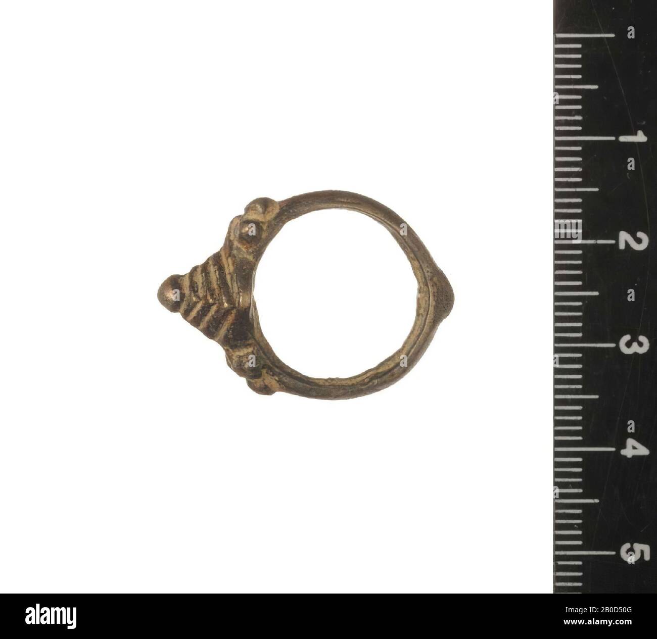 The ring has a small thickening at the bottom. At the top the ring is decorated with a pyramid shape built up of layers with a button on top. On both sides three balls have been applied for decoration. The used metal is not known (an alloy with copper ??). The origin is according to the accompanying documentation of mr. Bakker Afghanistan. The dating is according to this documentation Byzantine, and ended up in Afghanistan via trade routes, ring, metal, Dm. : 1.8 cm Stock Photo
