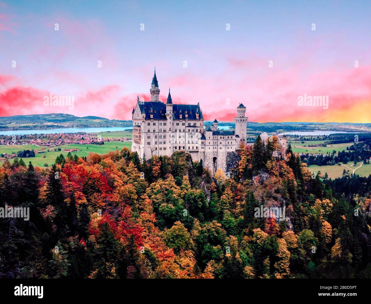 The famous Neuschwanstein castle during sunset, with colorful panorama of Mountain in the background Stock Photo
