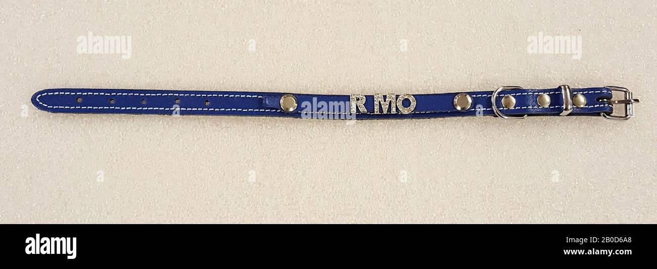 Narrow blue collar with stitching, rectangular buckle, belt pass, bracket for hooking strap and three circular nails. A narrower strap has been attached to the collar with two nails, the letters RMO with fake diamonds, collar, leather, batter, leather with metal fittings and plastic, Length 31 cm, width 1.3 cm, imposed band width 0.8 cm, height letters 1.0 cm, modern Stock Photo