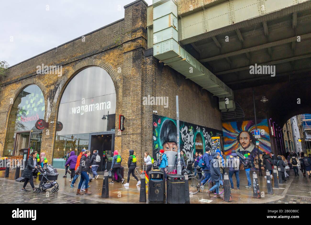 Entrances to Wagamama and Nando's restaurants in Southwark Arches on the South Bank Queen's Walk, London SE1 on a wet day Stock Photo