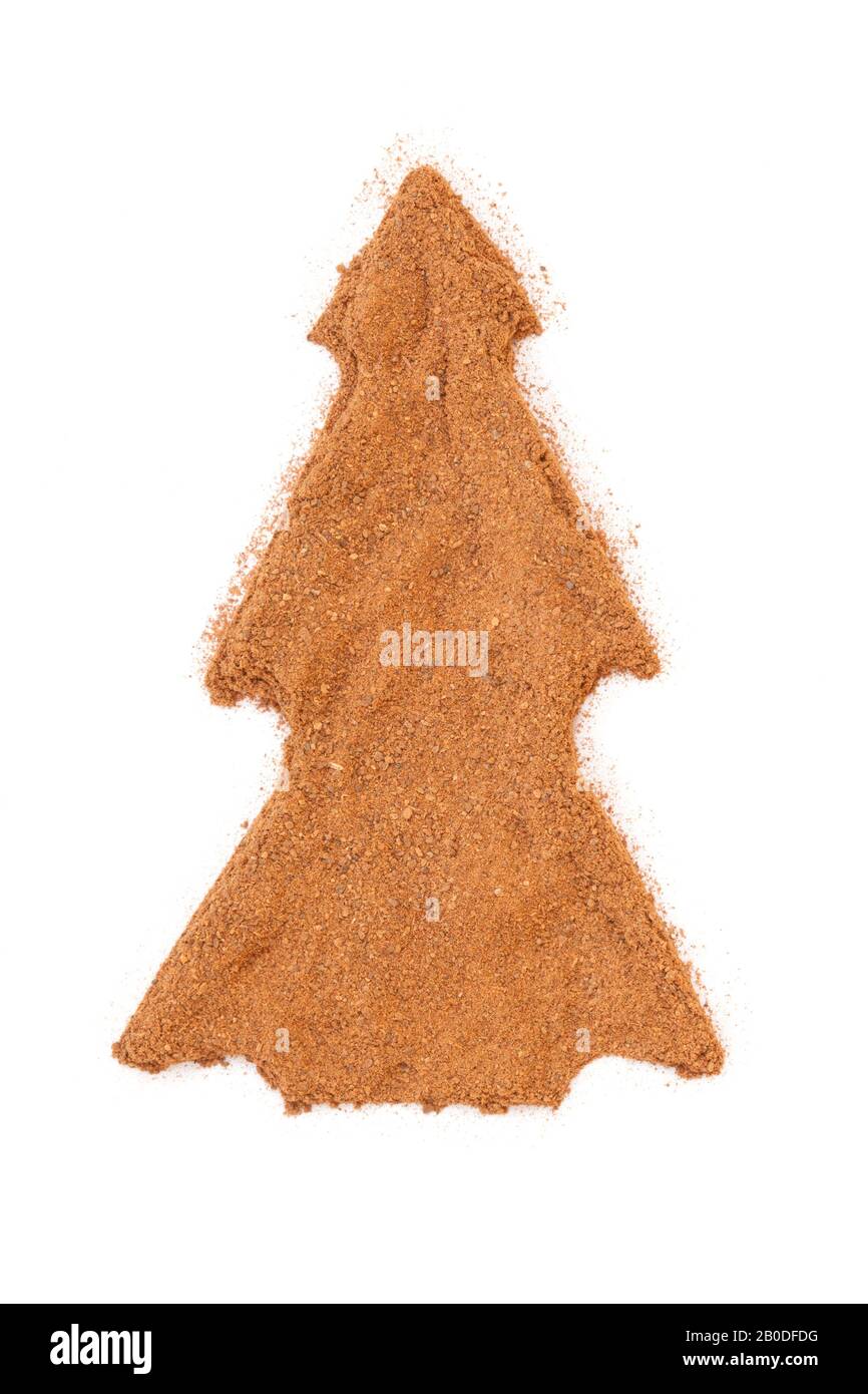 Heap of ground Cinnamon isolated in christmas tree shape on white background.  As a spice or condiment cinnamon sold in the form of sticks or a hammer Stock Photo