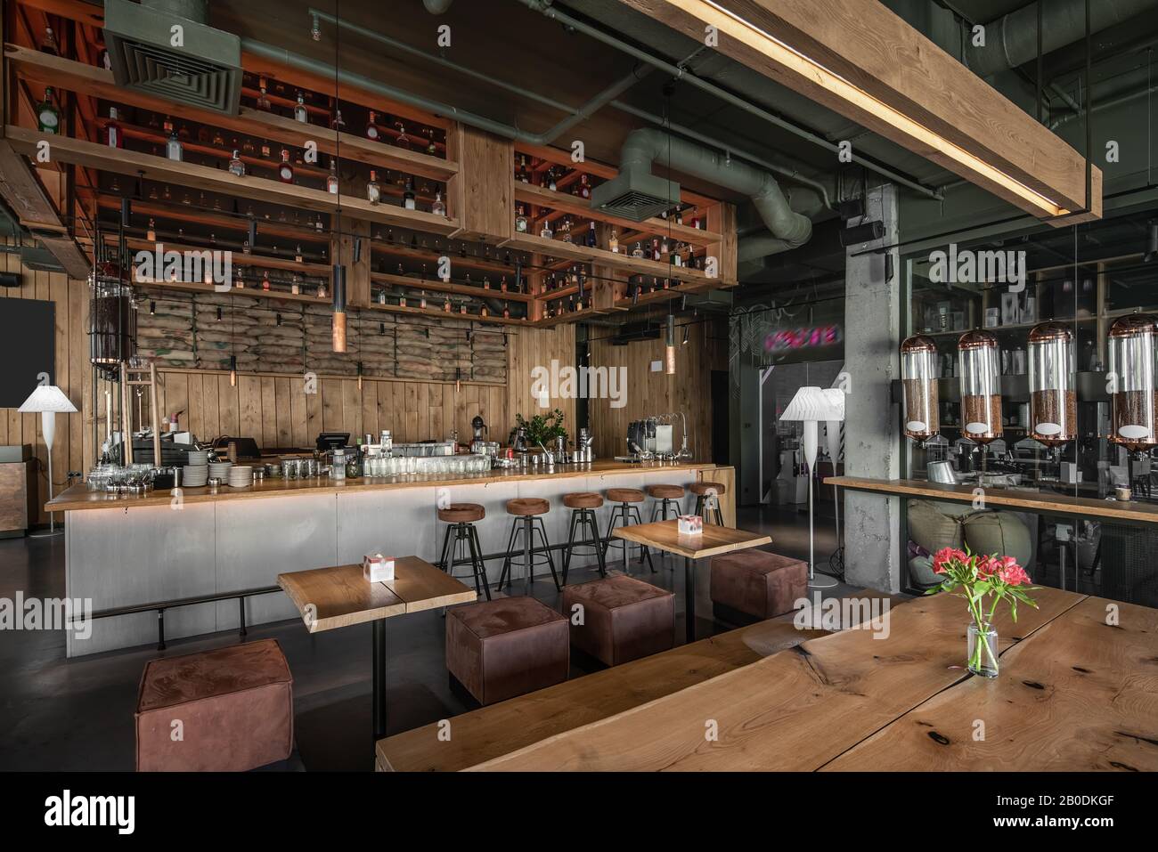 Trendy coffee house in a loft style with wooden walls and concrete columns. There are tables