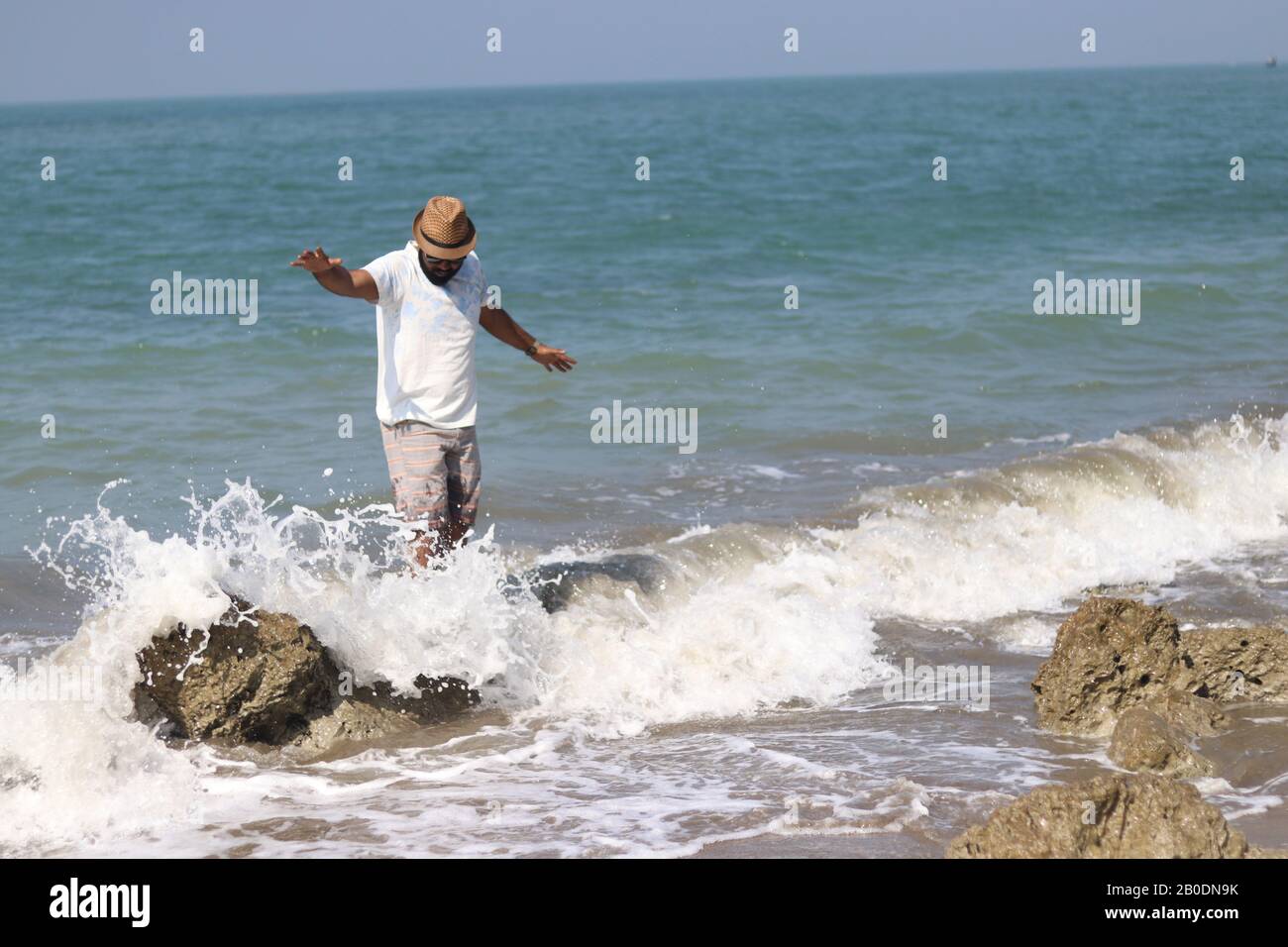 Stylish boy on sea wave Stock Photo