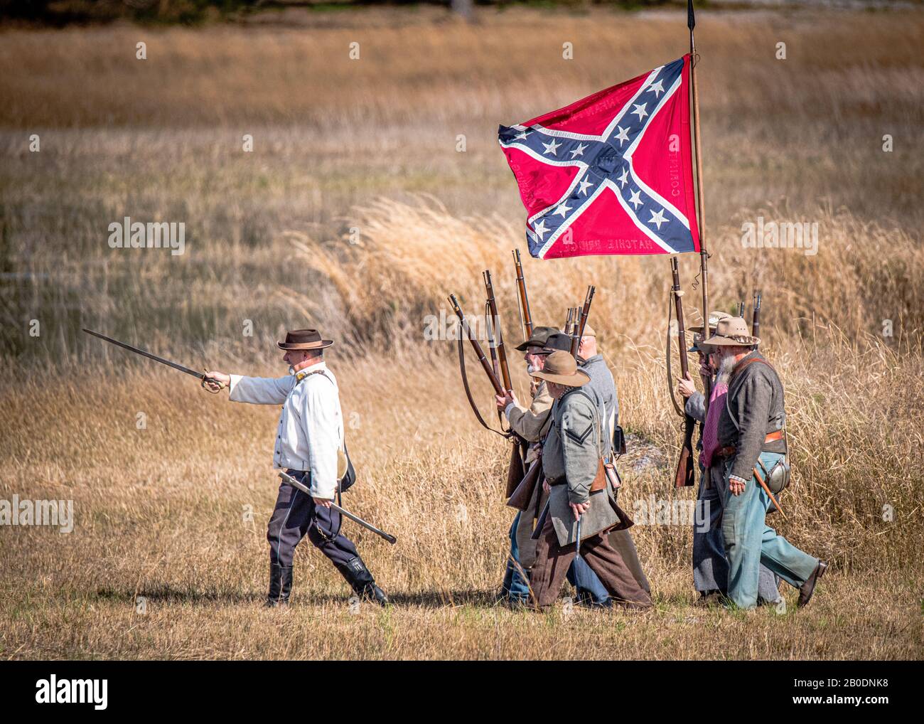 Brooksville, FL - January 18, 2020: Reenactor leads his civil war soldiers to the battle, under the colors of the confederate battle flag. Stock Photo