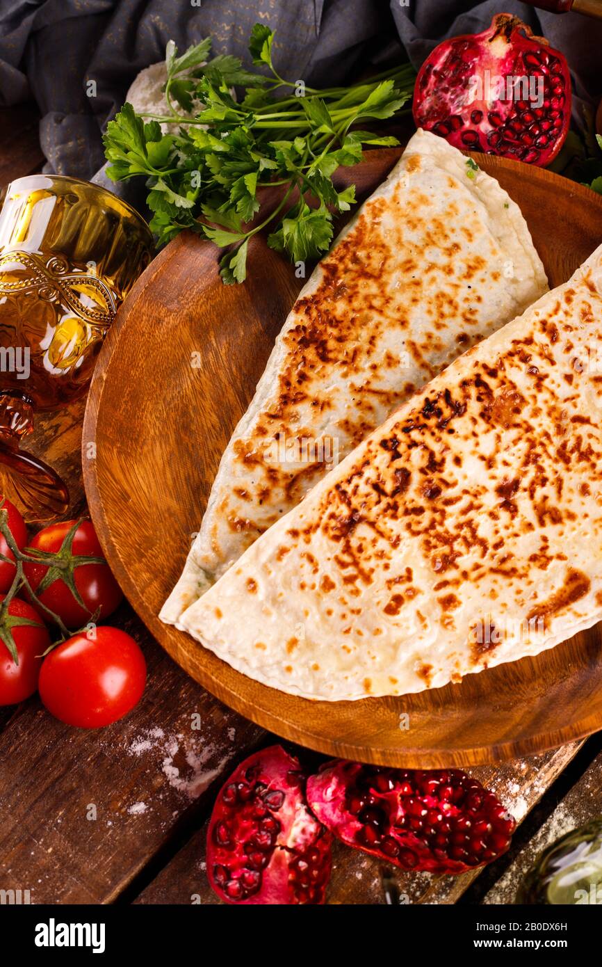 Azerbaijani national cuisine is distinguished by kutabs on a plate. Top view and wood background Stock Photo