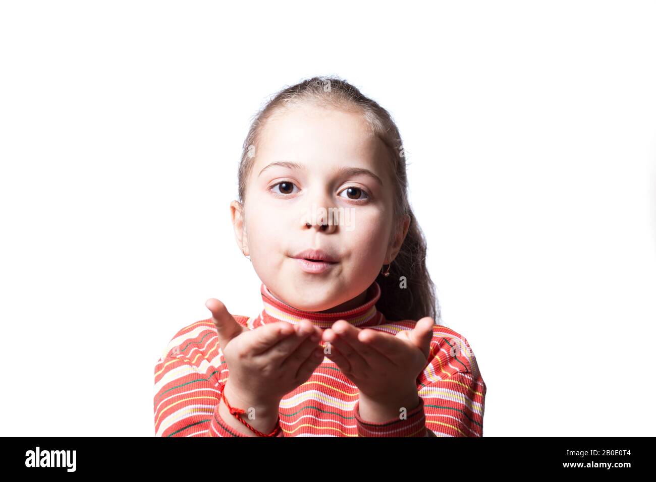 Little girl blows a kiss. Girl on a white background transfers her kisses Stock Photo