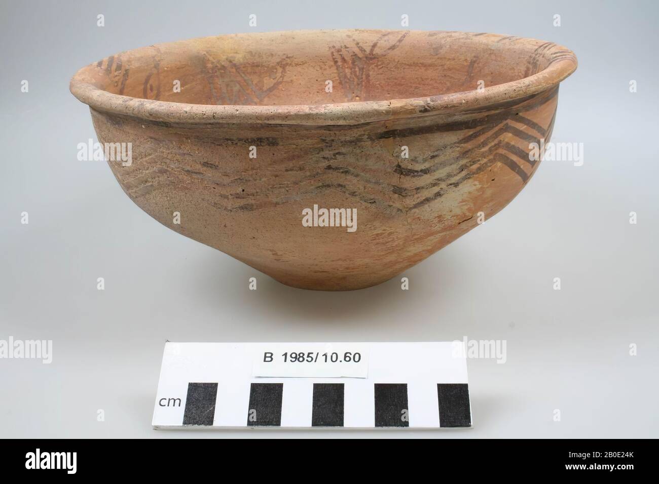 A deep wide bowl with on the inside a painting of a brown net-decoration on a pink background and on the outside a black zigzag line, just below the edge., Crockery, earthenware, H 12 cm, D 23.2 cm, Bronze Age, Iron Age I 2000-1000 BC, Iran Stock Photo