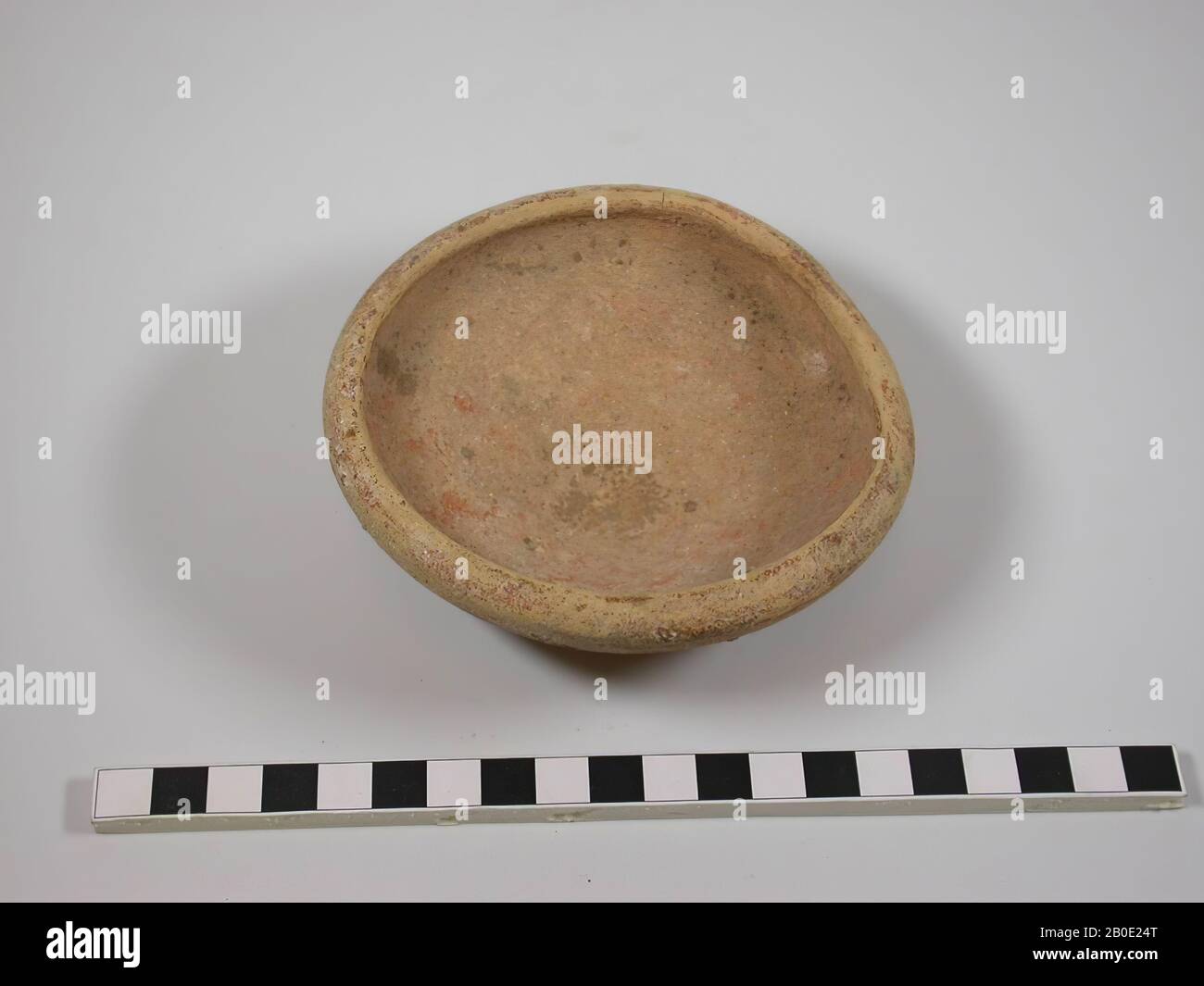 The bowl has a round base surrounded by a rim. From the foot the walls diverge widely until they pass unnoticed into a thickened raised edge. The color is light red with traces of dark red sludge. An indistinct little black drawing can be seen on the wall. The wall is also marked with a diagonal cross 'X', crockery, pottery, D max 11.1 cm, H 4.1 cm, D foot 5 cm, Roman Period? 63 BC. - 324 AD, Palestine Stock Photo