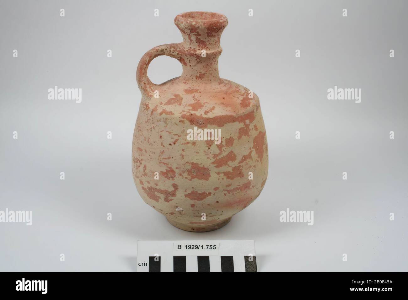 An earthenware jug with ring bottom, sharp kink to the shoulder, one